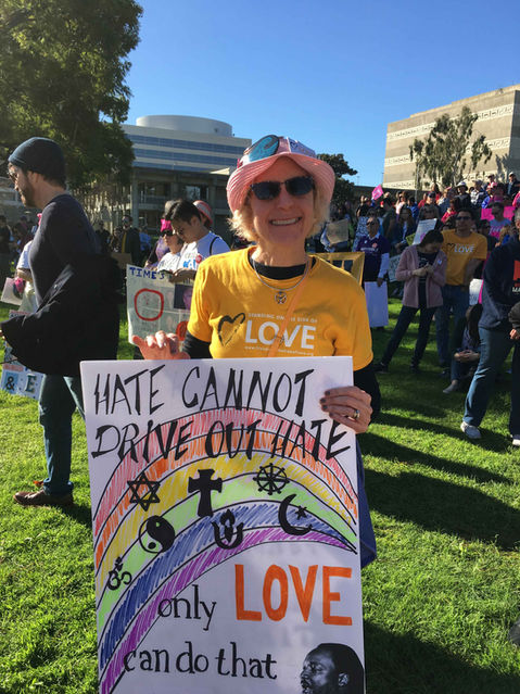 UU member at a protest holding a placard saying "Hate cannot drive out hate only love can do that"