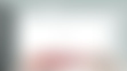A stark, modern room with white walls and a patterned floor, marked by a vivid pool of my blood — a jarring interruption to the otherwise pristine, clinical space.
