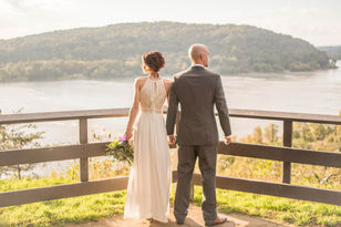 Bride and groom standing together overlooking a river