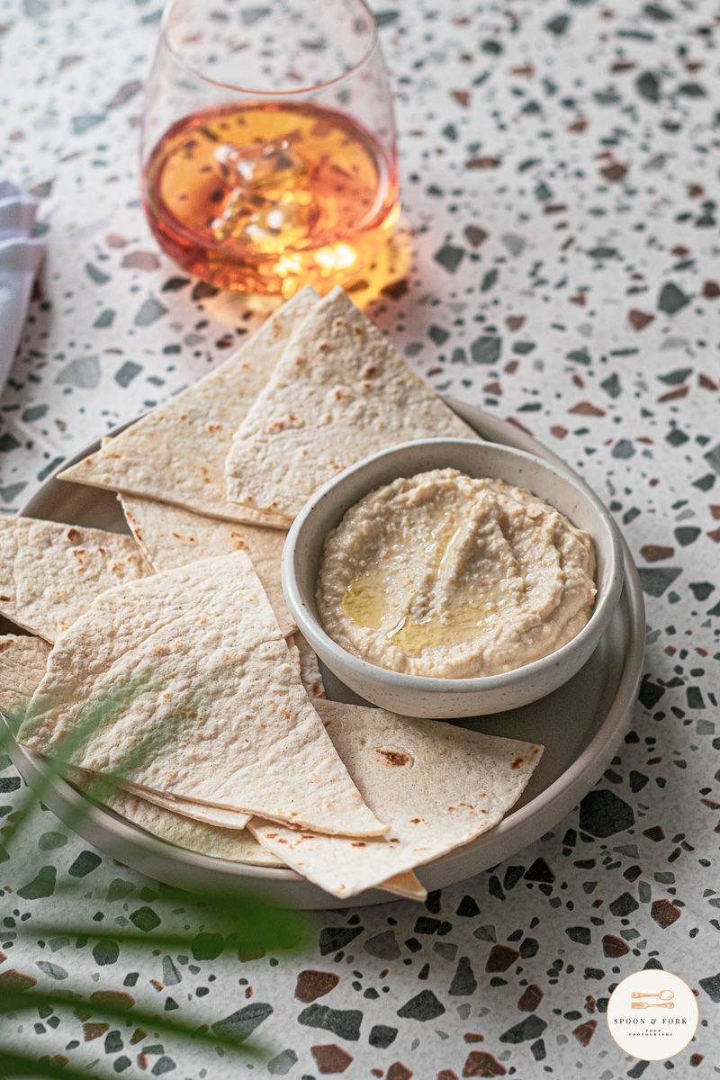 A portion of home made hummus on a bench