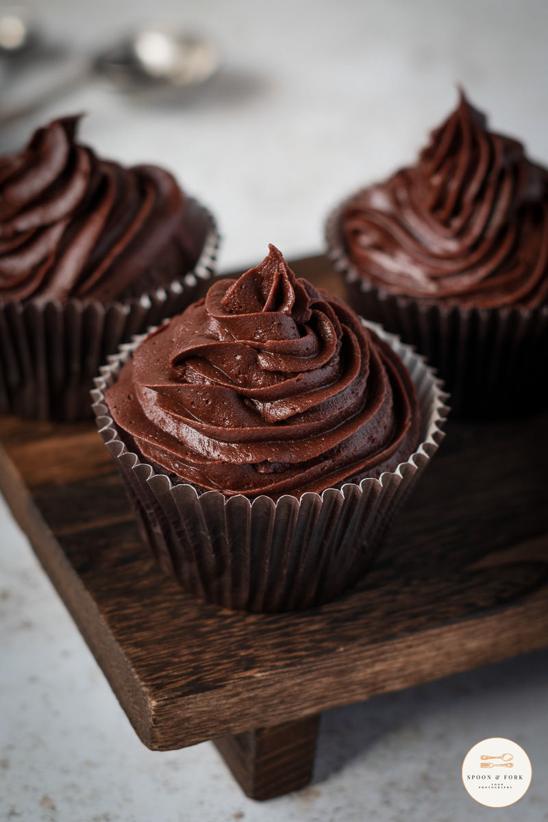 A serving of chocolate cupcakes frosted on a bench