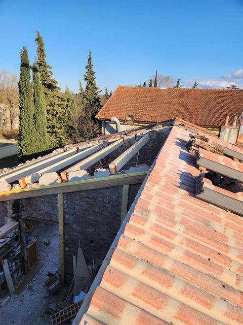 Chantier de rénovation de toiture avec nouvelle charpente bois et pose de tuiles