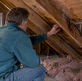 Homeowner inspecting attic ice dam damage