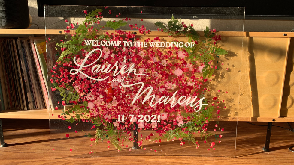 Custom welcome sign made of pressed flowers, resin, and acrylic sheeting.