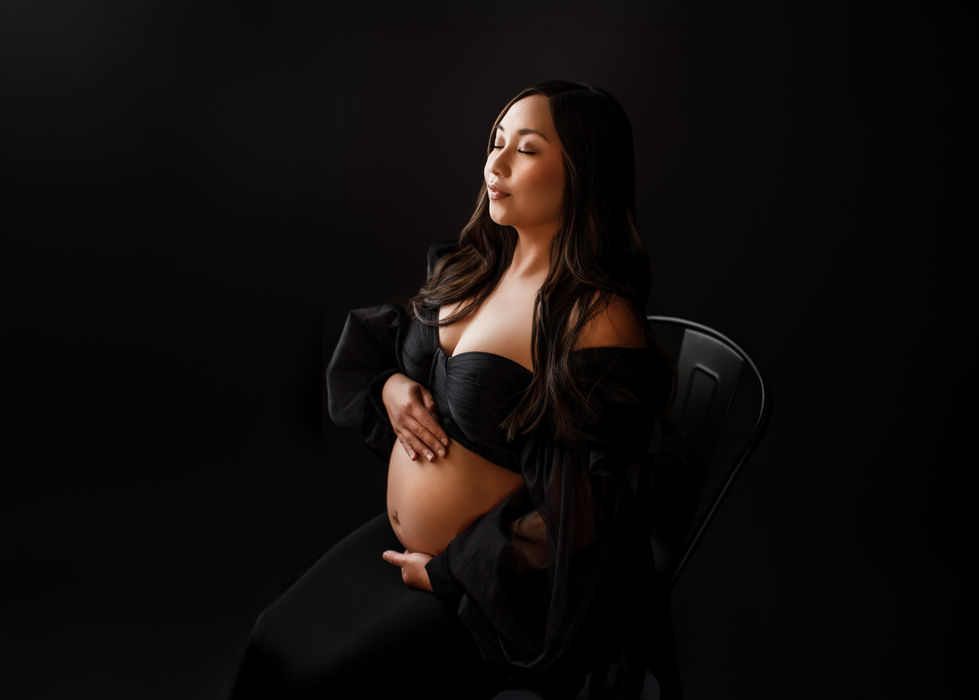 a pregnant woman is sitting in a chair with her eyes closed