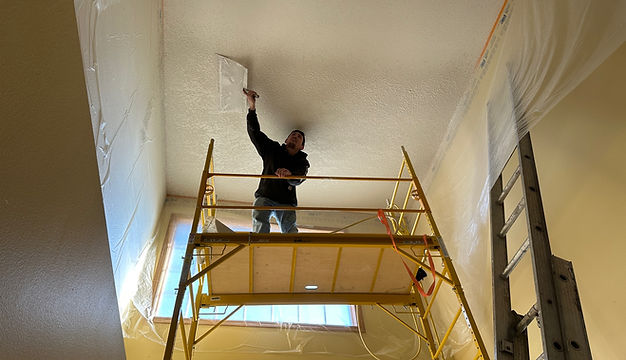 A Rocket Patch employee spraying ceiling texture