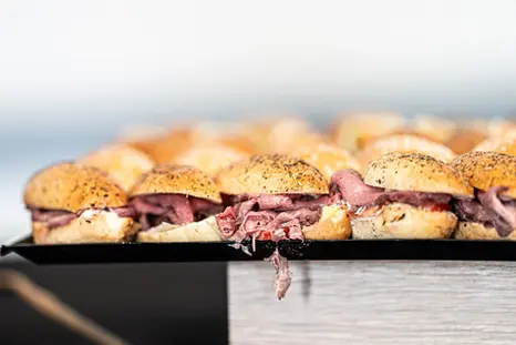 Photographie de plateaux de mini-sandwichs préparés pour un événement d’entreprise.