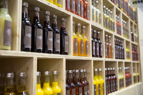 Photographie de bouteilles artisanales présentées dans un espace de vente d’entreprise.