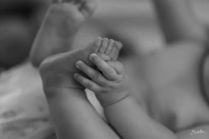 Main d’un nouveau-né tenant le doigt d’un adulte