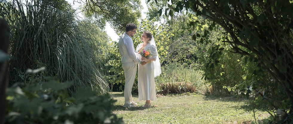 Couple de mariés échangeant un regard dans un jardin lors d’un reportage de mariage réalisé par un photographe professionnel.