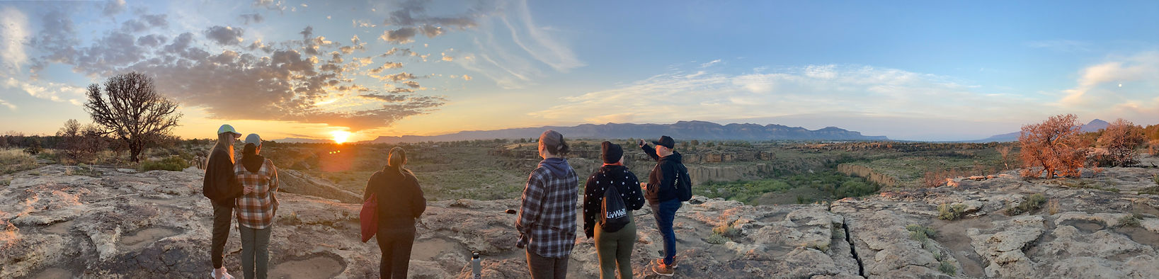 A group of people watching the sunrise in Cortez, Colorado with the backdrop of Mesa Verde National Park. 