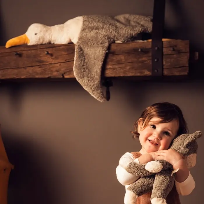 Boy smiling while holding a Senger Naturwelt Large Seagull plush companion