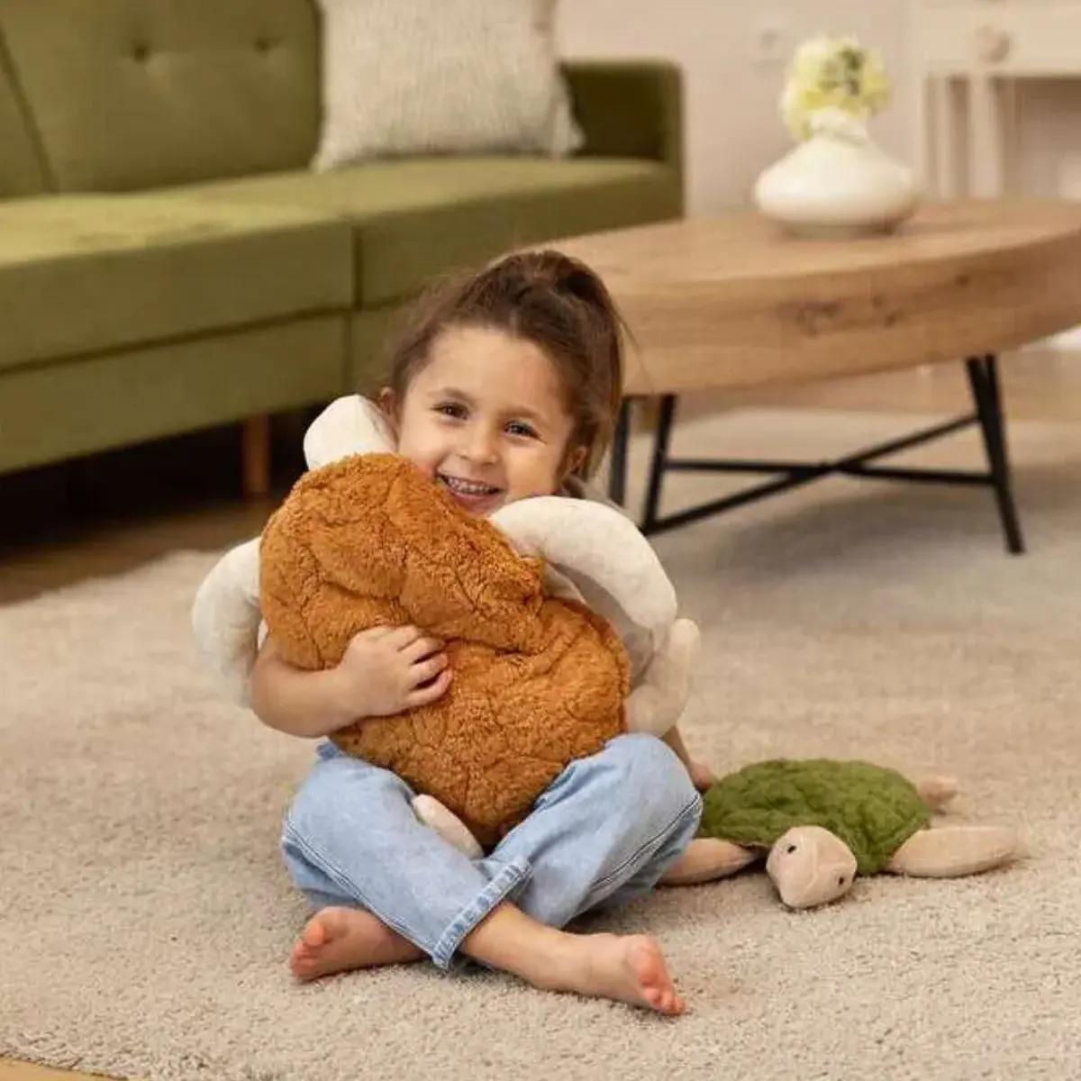 Girl smiling while holding a Senger Naturwelt Large Rust Turtle plush companion