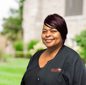 Smiling African American woman wearing glasses poses outside, Hardon Education.