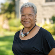 Smiling woman, short grey hair wearing black top and necklace, Hardon Education.