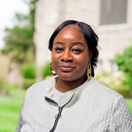 Headshot of a smiling Black woman, wearing a white sweater, outdoors. Hardon Education