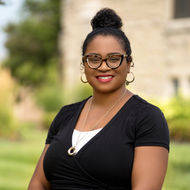 Smiling woman wearing glasses stands for a portrait, ABOUT Hardon Education