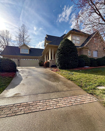 Concrete Driveway and Stone House with Garage