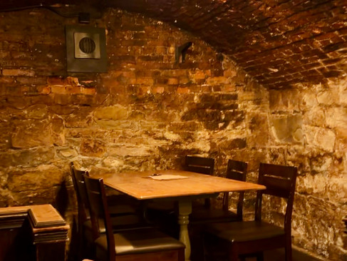 Pub tables in a brick cellar setting