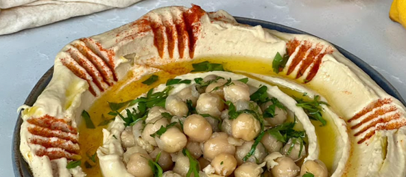 An image of hummus with chickpeas on top