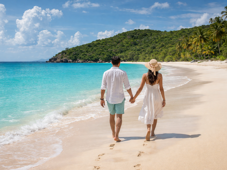 A couple walking hand-in-hand on the secluded, pristine sands of Rendezvous Bay in Antigua.