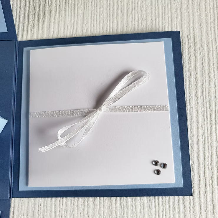 Geschenkbox zur Hochzeit als Geldgeschenk für eine Reise mit einem Grußkärtchen an der Seite mit Schleifenband geschlossen.