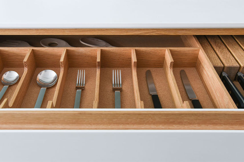 Detail of custom-veneered European oak drawer internals with solid oak cutlery divisions, cork bases and integrated magnetic knife block in the Clerkenwell kitchen by Jack Trench Design.