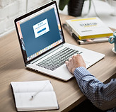Person logging in on a laptop at a desk