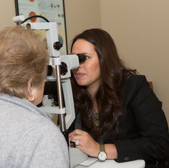 Optometrist examining patient's eye with a slit lamp