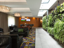 Hotel lobby featuring a green plant wall
