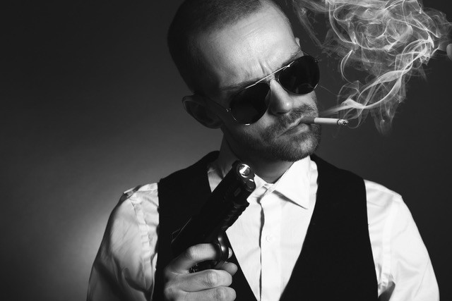 Villain with gun, cigarette, and dark glasses