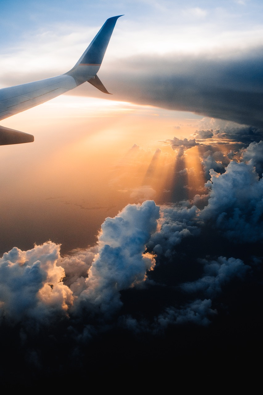Plane flying in sunset clouds