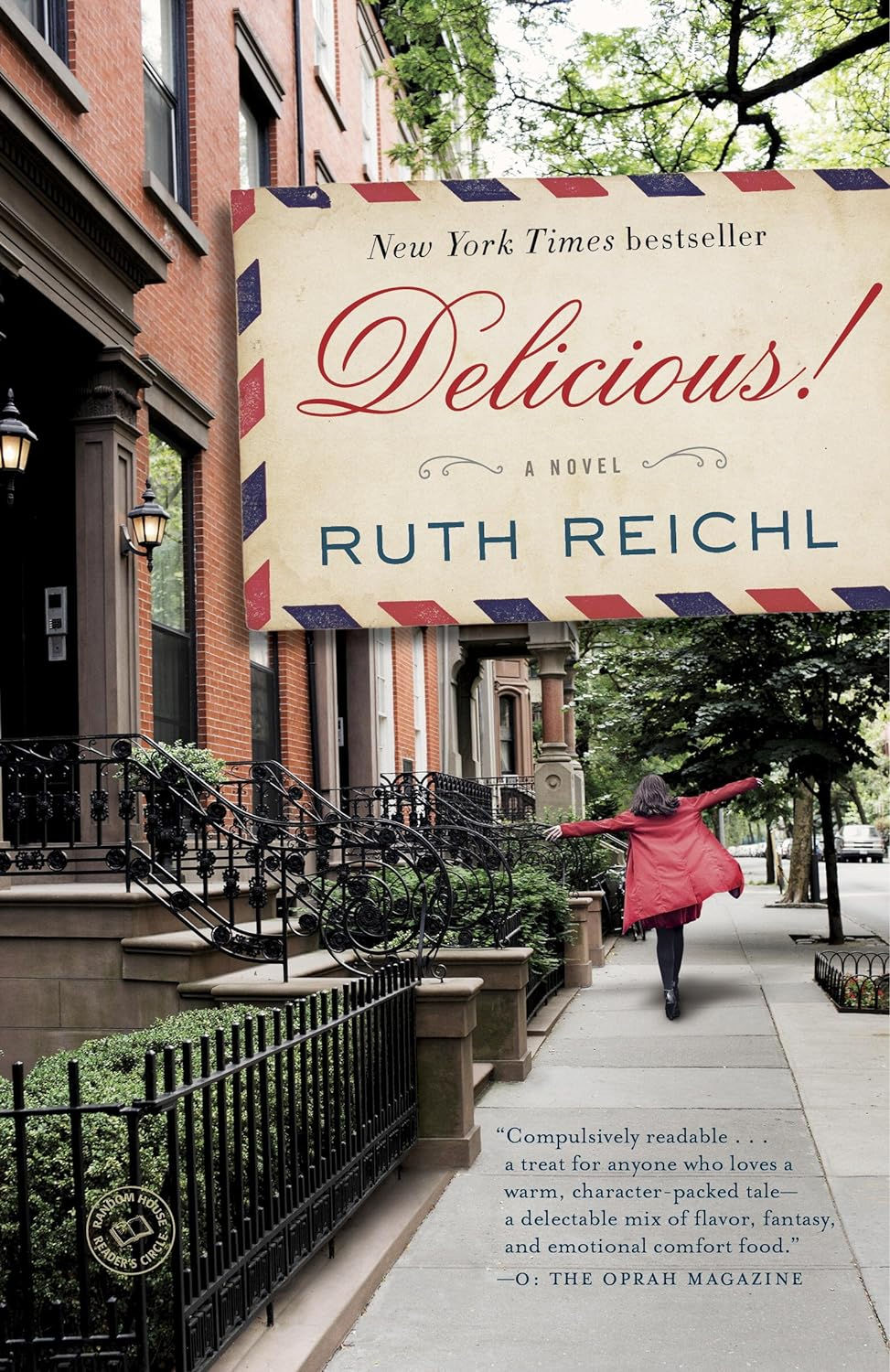 A young woman in a red coat, her arms outstretched, walks on a street flanked by brownstones; cover of Ruth Reichl's Delicious!