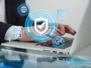 Hands typing on a laptop with digital icons overlay, including a shield and graphs, suggesting cybersecurity. The mood is focused.