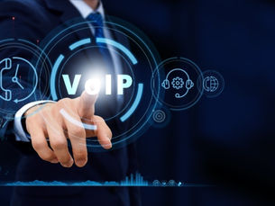 A person in a suit points at a holographic "VoIP" display with tech icons on a dark blue background, conveying innovation and technology.