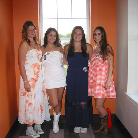 four girls dressed in Auburn colors smile together