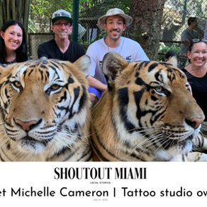 Color photo of the Cameron family sitting with two tigers.
