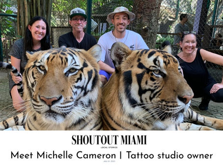 Color photo of the Cameron family sitting with two tigers.
