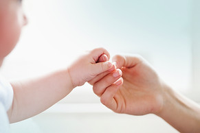 mother and baby touching hand