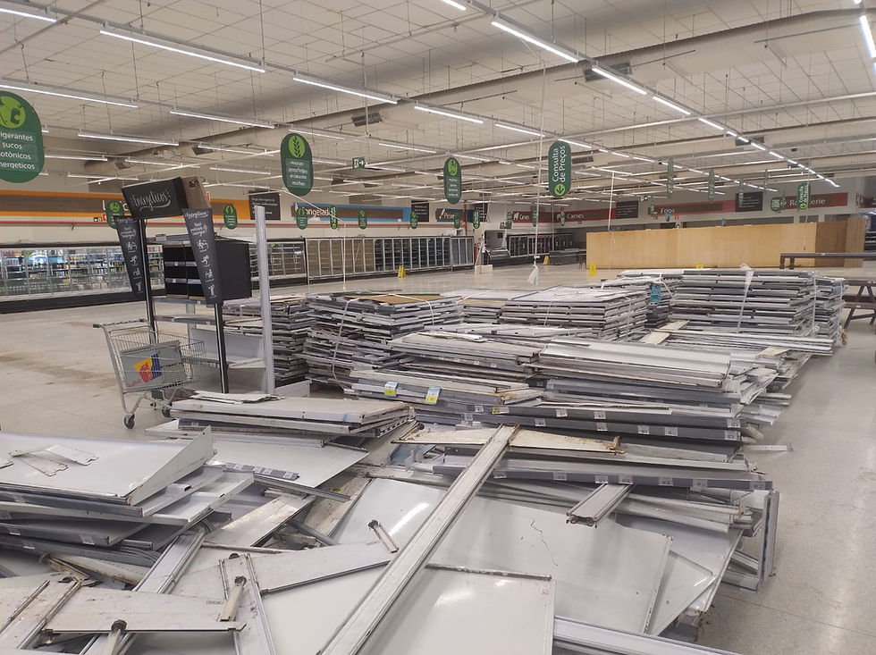 Prateleiras já desmontadas e amontoadas em um dos cantos da loja, à espera da remoção