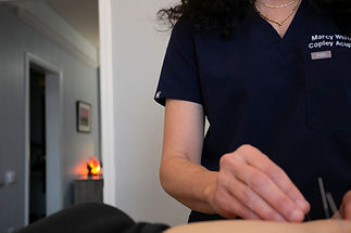 A picture of acupuncturist Marcy White needling a patient's hand in her office.