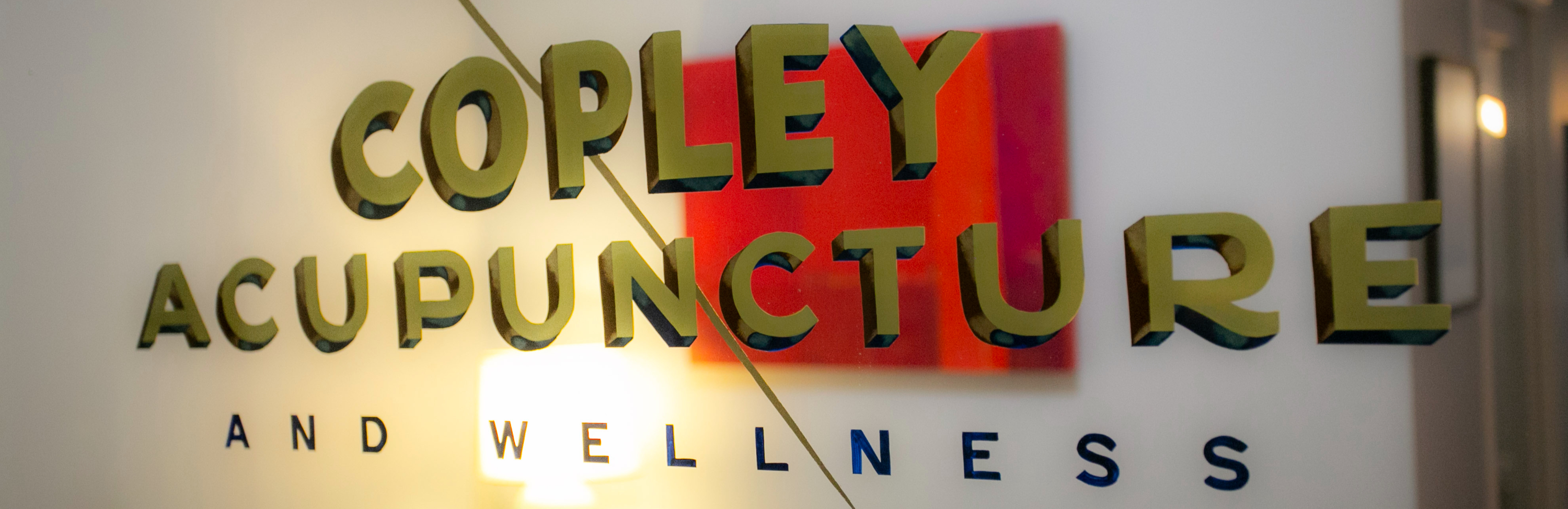 A photo of a hand painted sign in the window of Marcy' office that says Copley Acupuncture