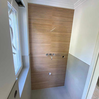 Duschraum mit Rückwand in Holzoptik