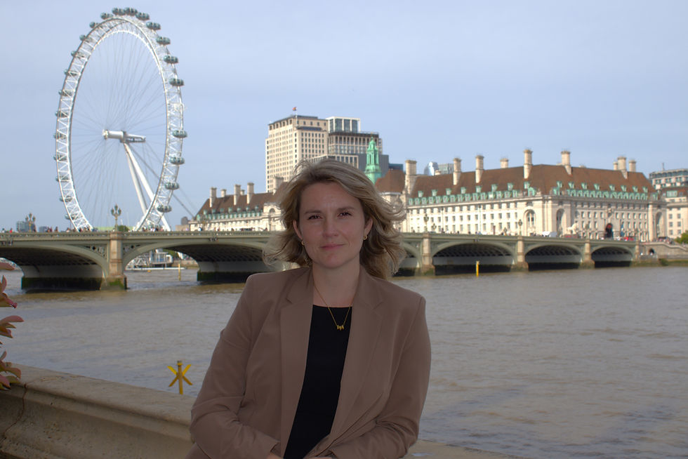 Jess Brown-Fuller stands outside Parliament, looking towards the camera.