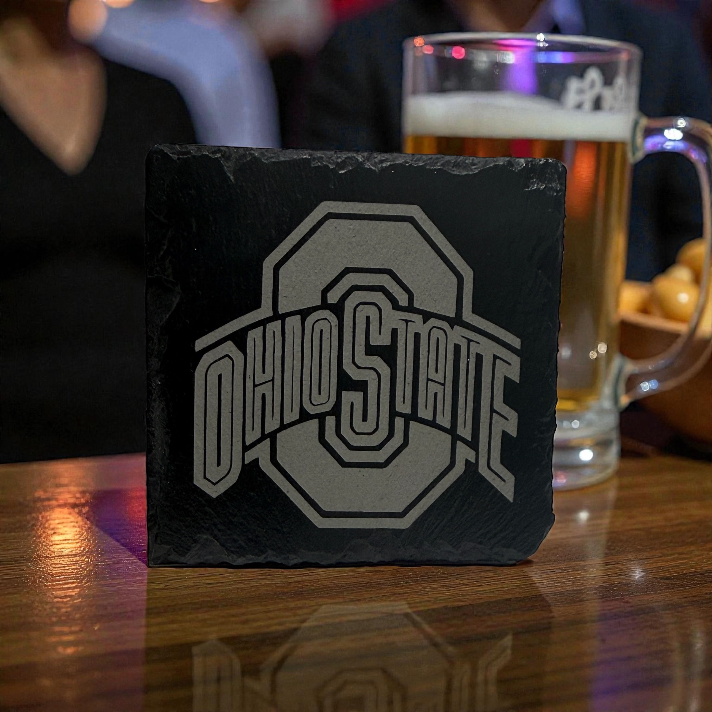 Ohio State logo slate coaster at a bar with beer