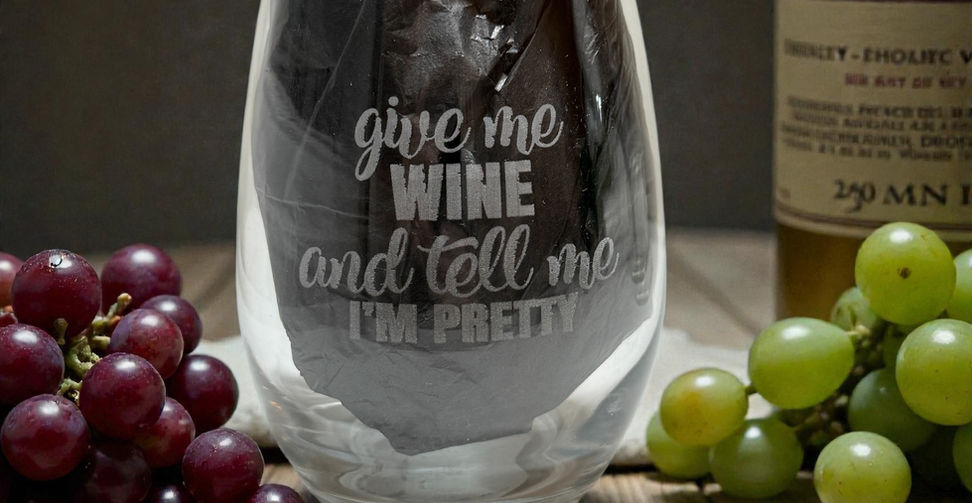 Wine glass with "give me wine and tell me I'm pretty" text, grapes.