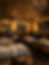 Warmly lit dining room at Ziba's Bistro & Wine Bar in Grant Park, Atlanta, featuring elegantly set tables, dark wood chairs, and a distinctive decorative ceiling.