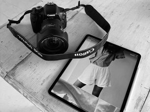 Camera and iPad with fashion images open on a table