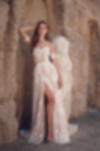 Woman in The Willow Gown - Vintage Lace Wedding Dress with High Slit posing near statue, Mysite