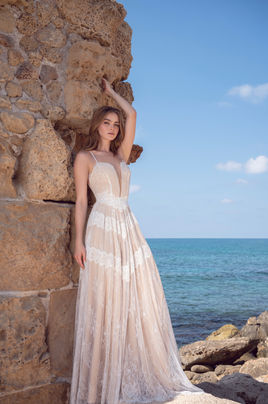 Full body shot of a romantic lace wedding dress with spaghetti straps and a tulle cover-up by Lace & Love by Shany Sasson.
